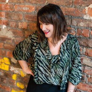 Lady in green and black top smiling 